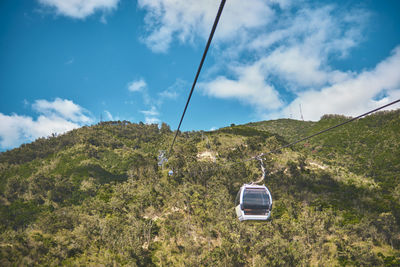 Modular cabins cable car against the bright sky, clouds ans mountains. cableway