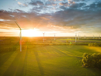 Aerial view of windturbine against sunset with moody golden lighting