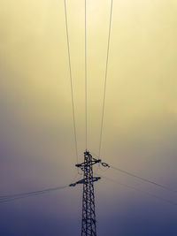 Low angle view of silhouette electricity pylon against sky during sunset