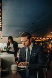 Young businessman using laptop while sitting in hotel lounge