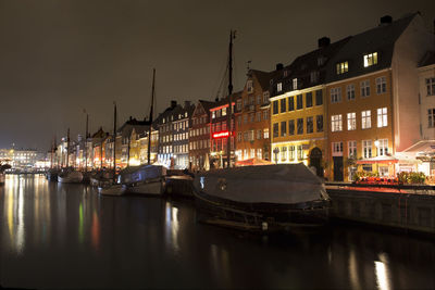 Boats in river in city at night