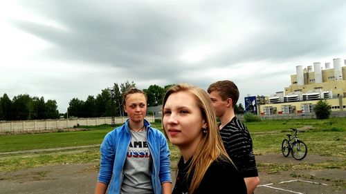Portrait of young friends against sky