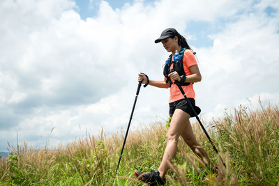 Young woman walking on grassy land