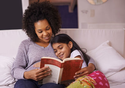 Mother telling story to daughter at home