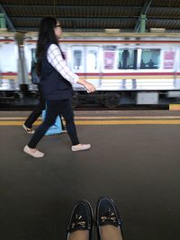 Woman standing on railroad station platform at night