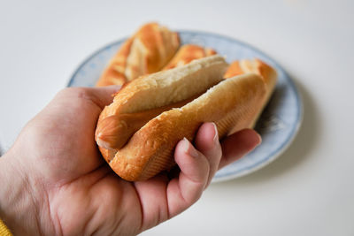 Close-up of hand holding bread in plate