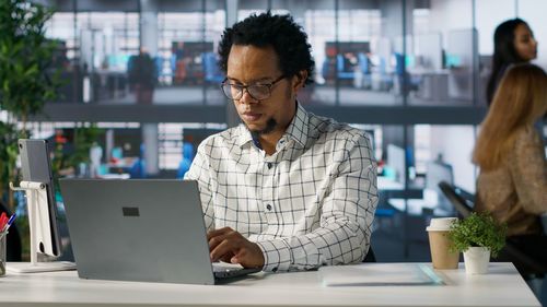 Young man using laptop at office