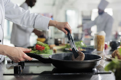 Midsection of man preparing food in kitchen