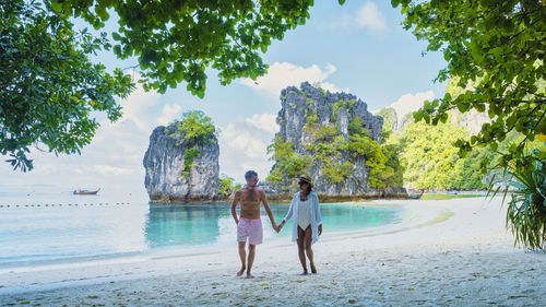 Rear view of woman walking at beach