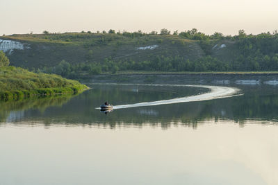 A rubber motor boat floats on a large river