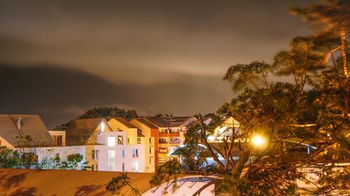 Illuminated buildings against sky at night