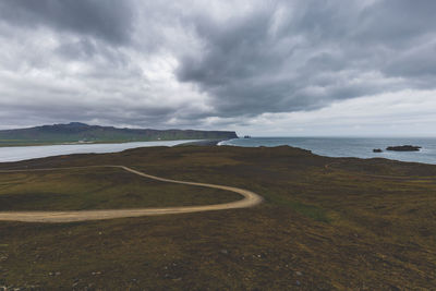 Scenic view of road by sea against sky