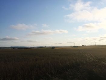 Scenic view of field against cloudy sky