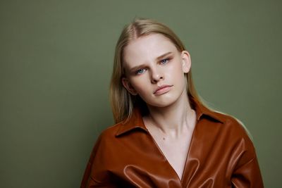 Portrait of young woman against wall