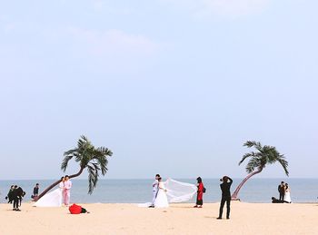 People at beach against sky