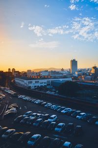 High angle view of cars in city against sky during sunset