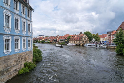 River amidst buildings in city against sky