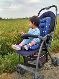 Girl sitting on chair in field