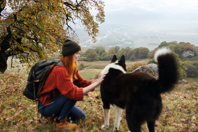 Rear view of man with dog on field