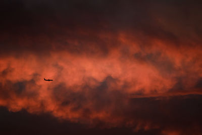 Low angle view of silhouette airplane against sky during sunset