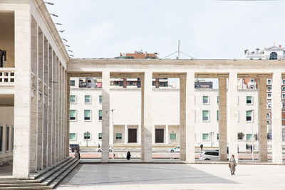 Building by street in city against sky