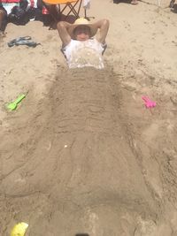 Low section of boy on sand at beach