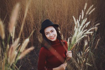 Portrait of smiling young woman standing on field