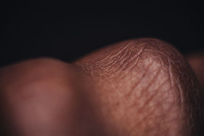 Close-up of hands against black background