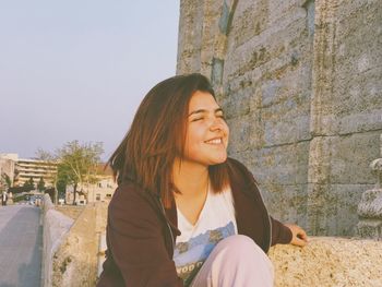 Portrait of smiling young woman sitting outdoors