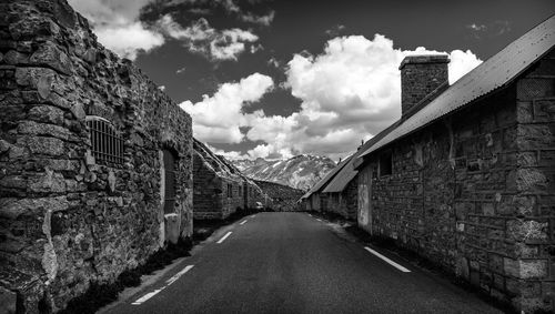 Road amidst buildings against sky