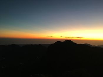 Scenic view of silhouette mountains against romantic sky at sunset