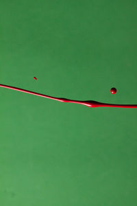 Close-up of red umbrella over green background