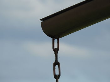 Low angle view of chain against sky