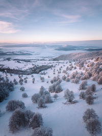 Scenic view of snow covered landscape against sky during sunset