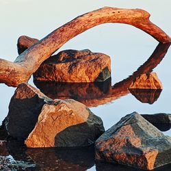 Close-up of rusty metal on rock against sky