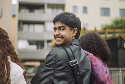 Portrait of smiling boy looking over shoulder with female friends