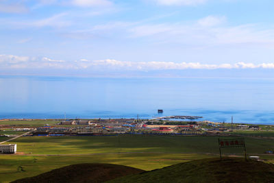 High angle view of city by sea against sky