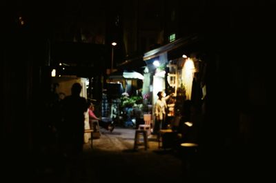 People in illuminated street at night