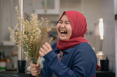 Laughing teenager girl holding flower