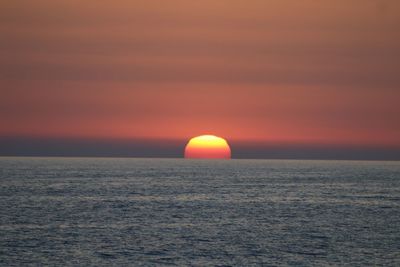 Scenic view of sea against orange sky