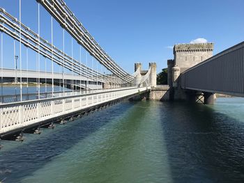 Bridge over river against sky in city