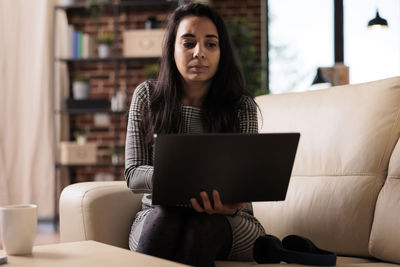 Young woman using laptop at home