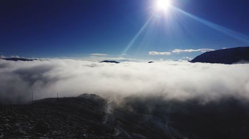 Low angle view of snowcapped mountains against sky on sunny day