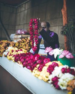 Vendor selling floral garlands at shop