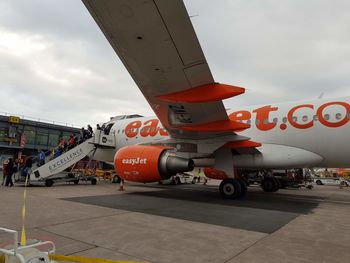 Airplane on airport runway against sky