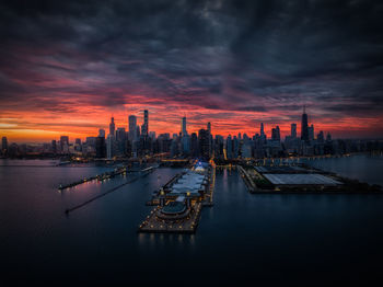 Boats moored at harbor during sunset