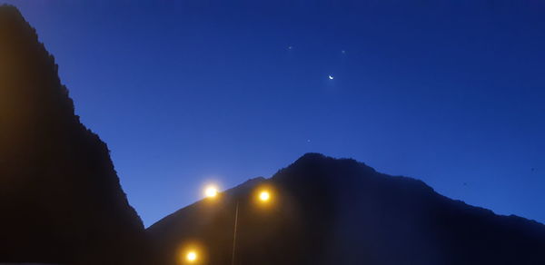 Low angle view of silhouette mountains against sky at night