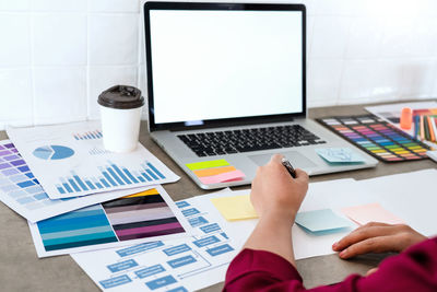 Low section of woman using laptop on table