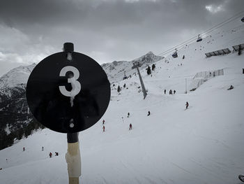 Text on snow covered mountain against sky