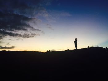 Silhouette man standing against sky during sunset